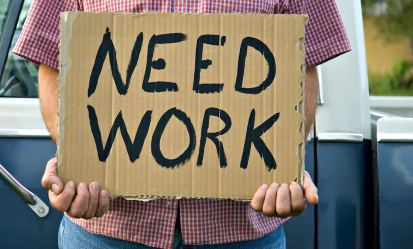 людина з табличкою про пошук роботи