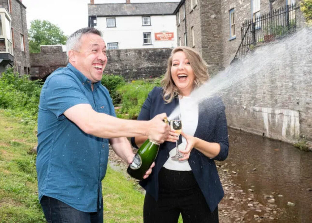 чоловік і жінка відкривають шампаньске