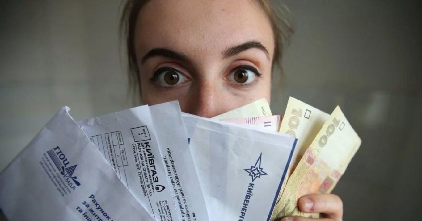 жінка із комунальними платіжками і грошима
