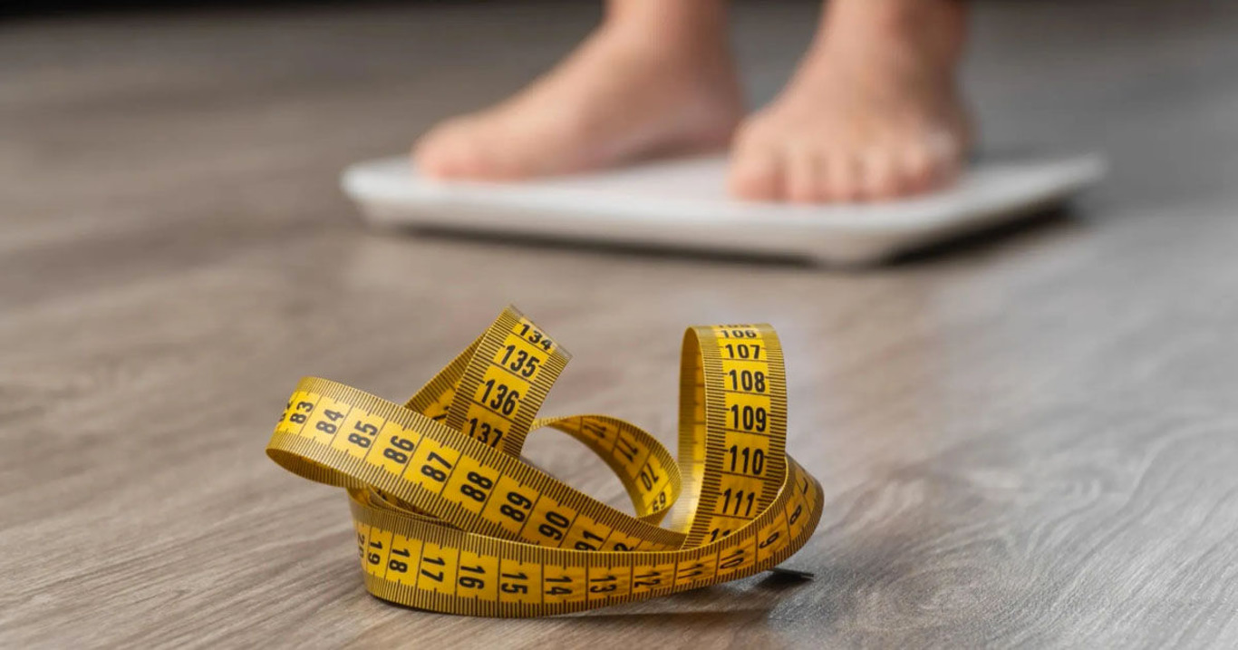 людина стоїть на вагах