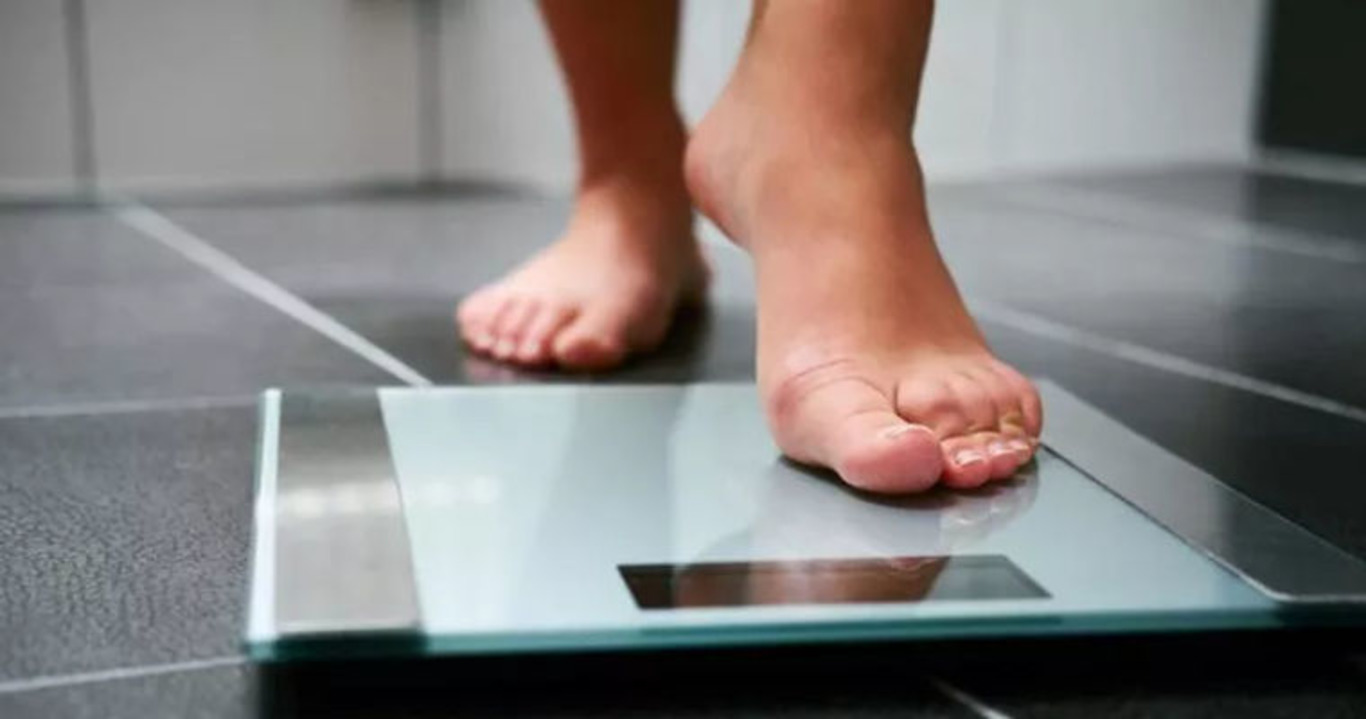 людина стоїть на вагах